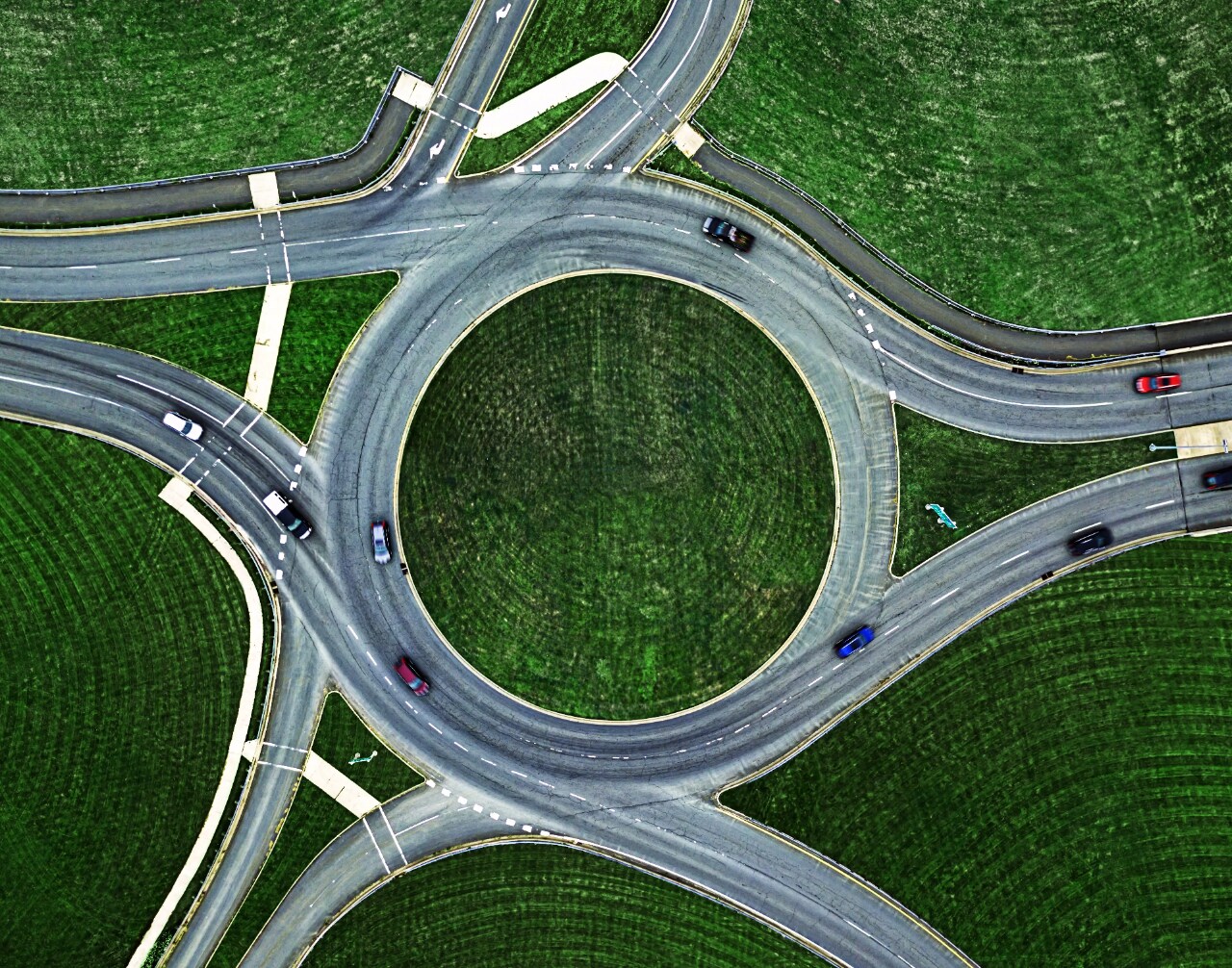 Aerial view of a highway interchange with cars moving on and off the ramps.